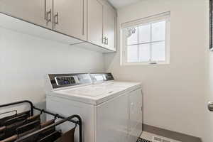 Laundry room featuring washer and clothes dryer and cabinet space