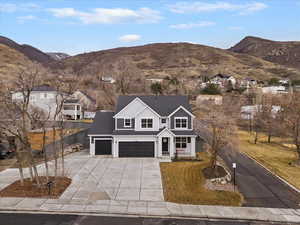 View of front facade featuring a mountain view, a garage, and concrete driveway