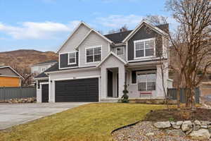 View of front of house featuring a garage, concrete driveway, brick siding, a mountain view, and board and batten siding