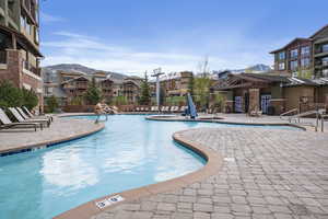 Community pool, hot tubs, and pool house featuring a patio and a mountain view