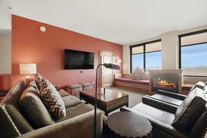 Living area featuring a glass covered fireplace and carpet floors