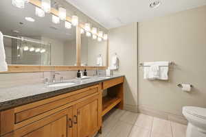 Bathroom featuring double vanity, a shower stall, light tile patterned flooring, and recessed lighting