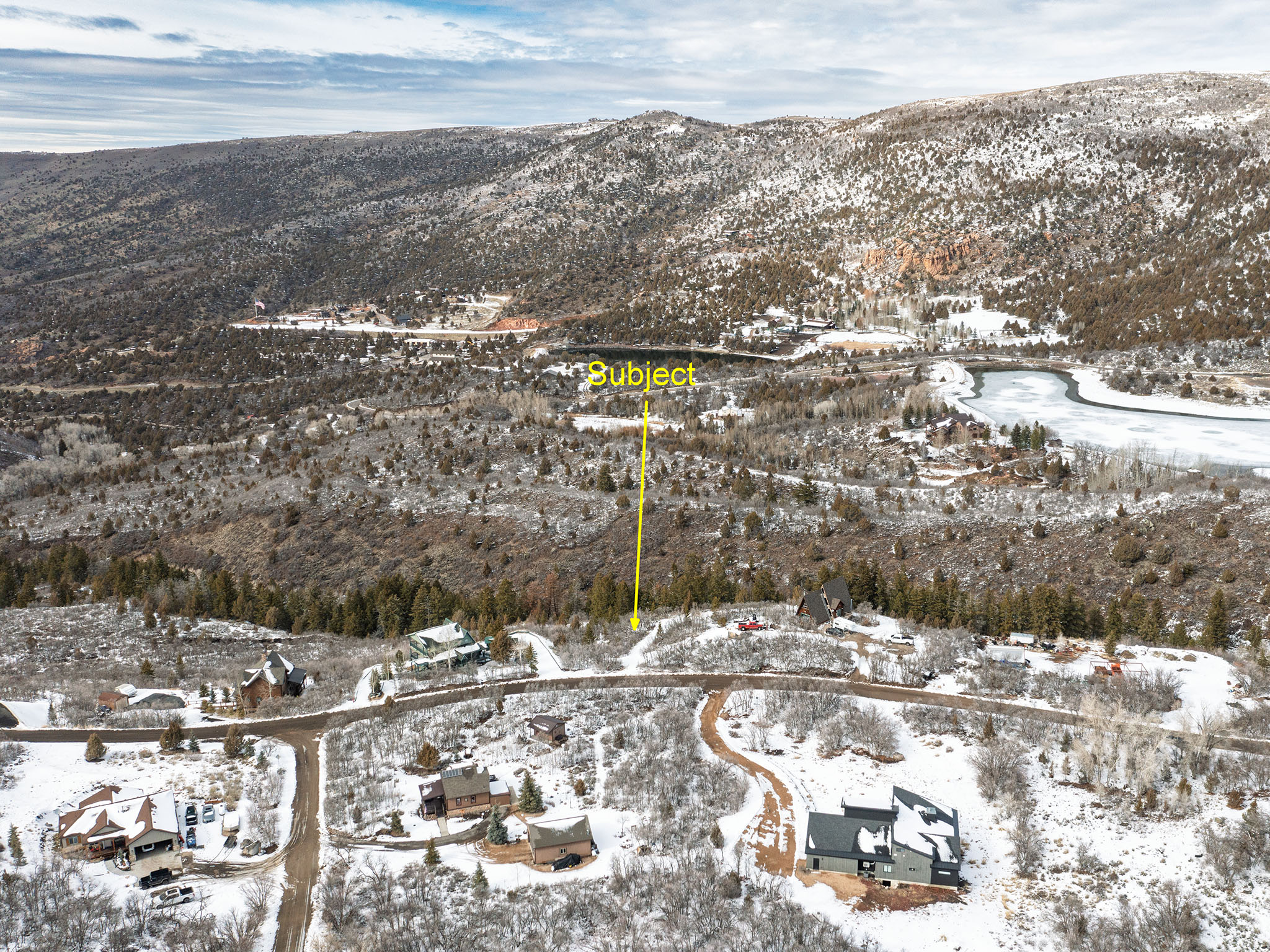 Snowy aerial view featuring a mountain view and a residential view
