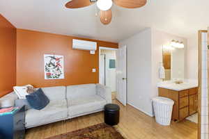 Living room with a ceiling fan, light wood-style floors, and electric panel