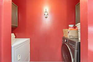 Laundry area featuring separate washer and dryer and cabinet space