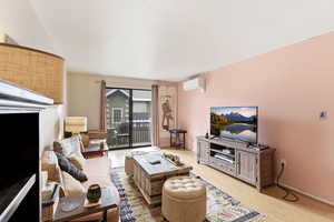 Living room with light wood finished floors and a mini split for heating / cooling