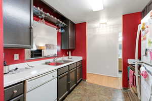 Kitchen featuring white appliances, light countertops, and stone finish flooring