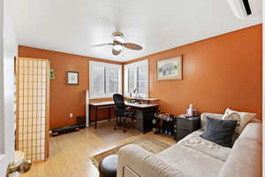 Office area with light wood finished floors and a ceiling fan