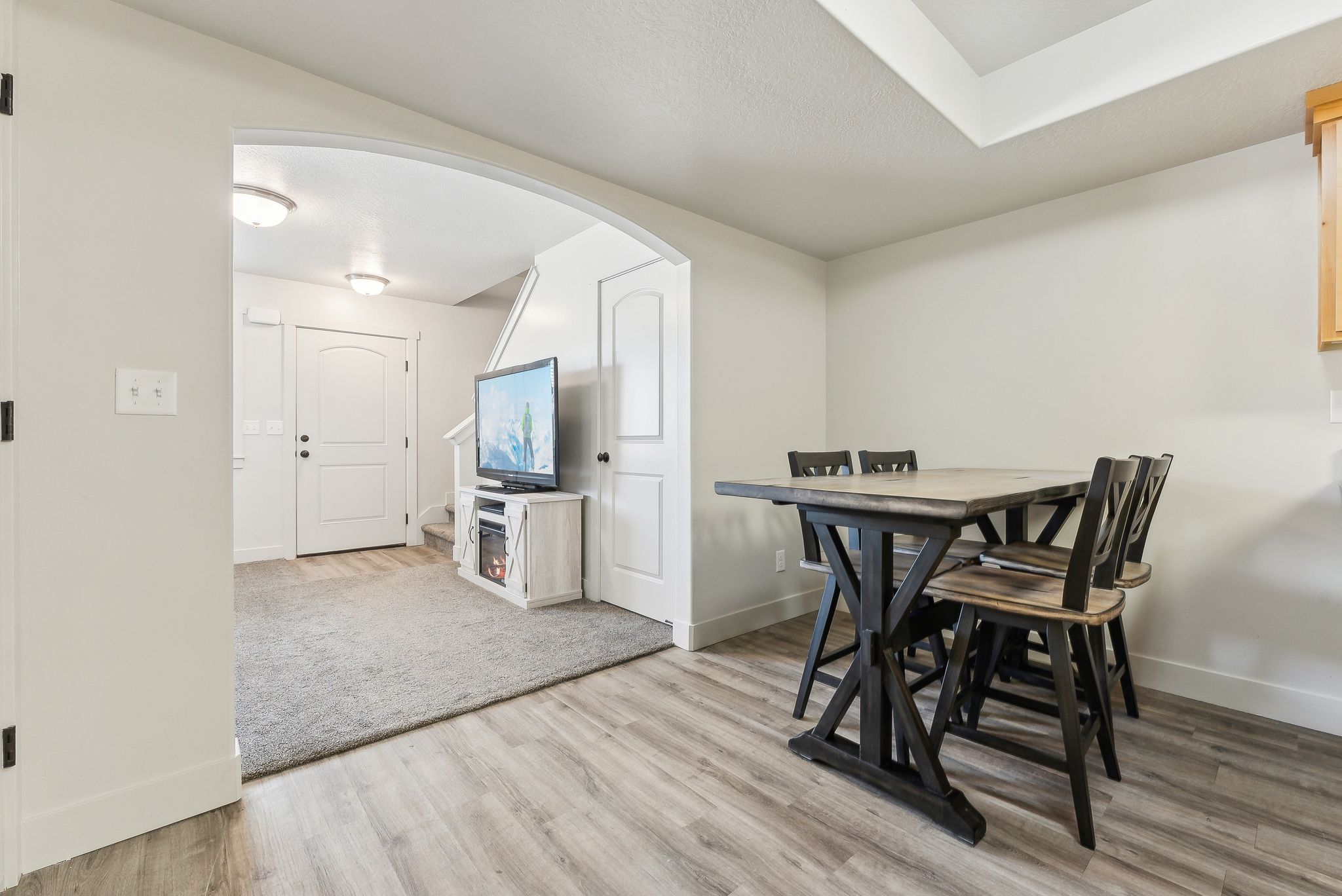 Dining room with arched walkways and light wood-style flooring