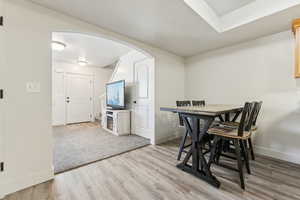 Dining room with arched walkways and light wood-style flooring