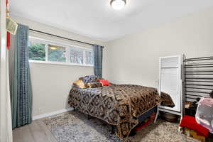 Bedroom with light wood-type flooring and baseboards