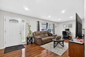 Living room featuring dark wood-style flooring, a desk, and recessed lighting