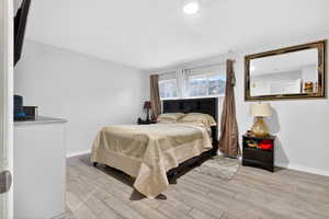 Bedroom with light wood-style floors and baseboards