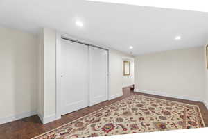 Unfurnished bedroom with dark wood-style flooring, recessed lighting, and a closet