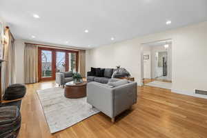 Living area with light wood-style flooring and recessed lighting