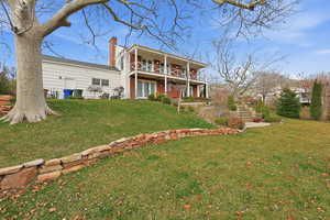 View of front of house with a chimney and a front lawn