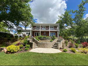 Back of house featuring french doors, a yard, a balcony, and a patio