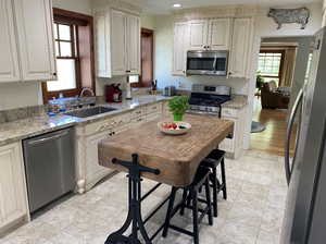 Kitchen featuring stainless steel appliances, light stone counters, healthy amount of natural light, and recessed lighting