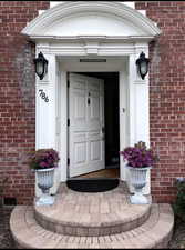 Entrance to property featuring brick siding