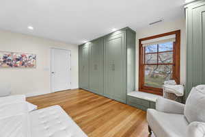 Living area with light wood-style flooring and recessed lighting