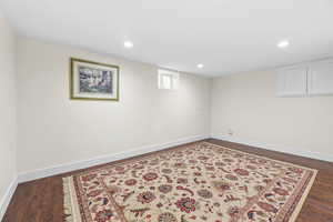 Below grade area featuring dark wood-style flooring and recessed lighting