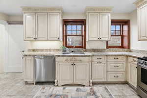 Kitchen with cream cabinetry, stainless steel appliances, and healthy amount of natural light