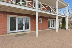 Back of house featuring french doors, brick siding, and a patio area