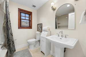 Bathroom with a shower with curtain and light tile patterned floors