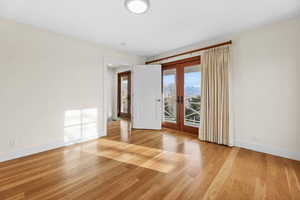 Empty room with french doors and light wood-type flooring