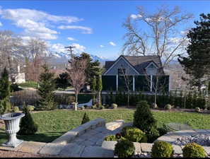 Rear view of property with a lawn and a mountain view