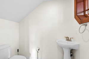 Half bath featuring lofted ceiling