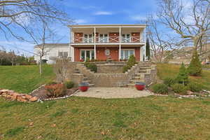 View of front of house featuring a front lawn, brick siding, a porch, and a patio area