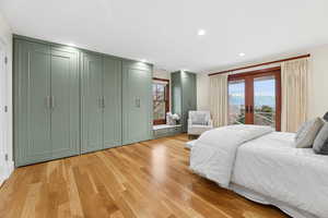 Bedroom featuring two closets, french doors, light wood-style floors, access to outside, and recessed lighting