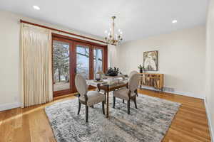 Dining space with suspended lighting and light wood-type flooring
