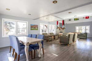 Dining area featuring wood walls, wood finished floors, and a stone fireplace