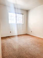 Unfurnished room featuring carpet flooring and a textured ceiling