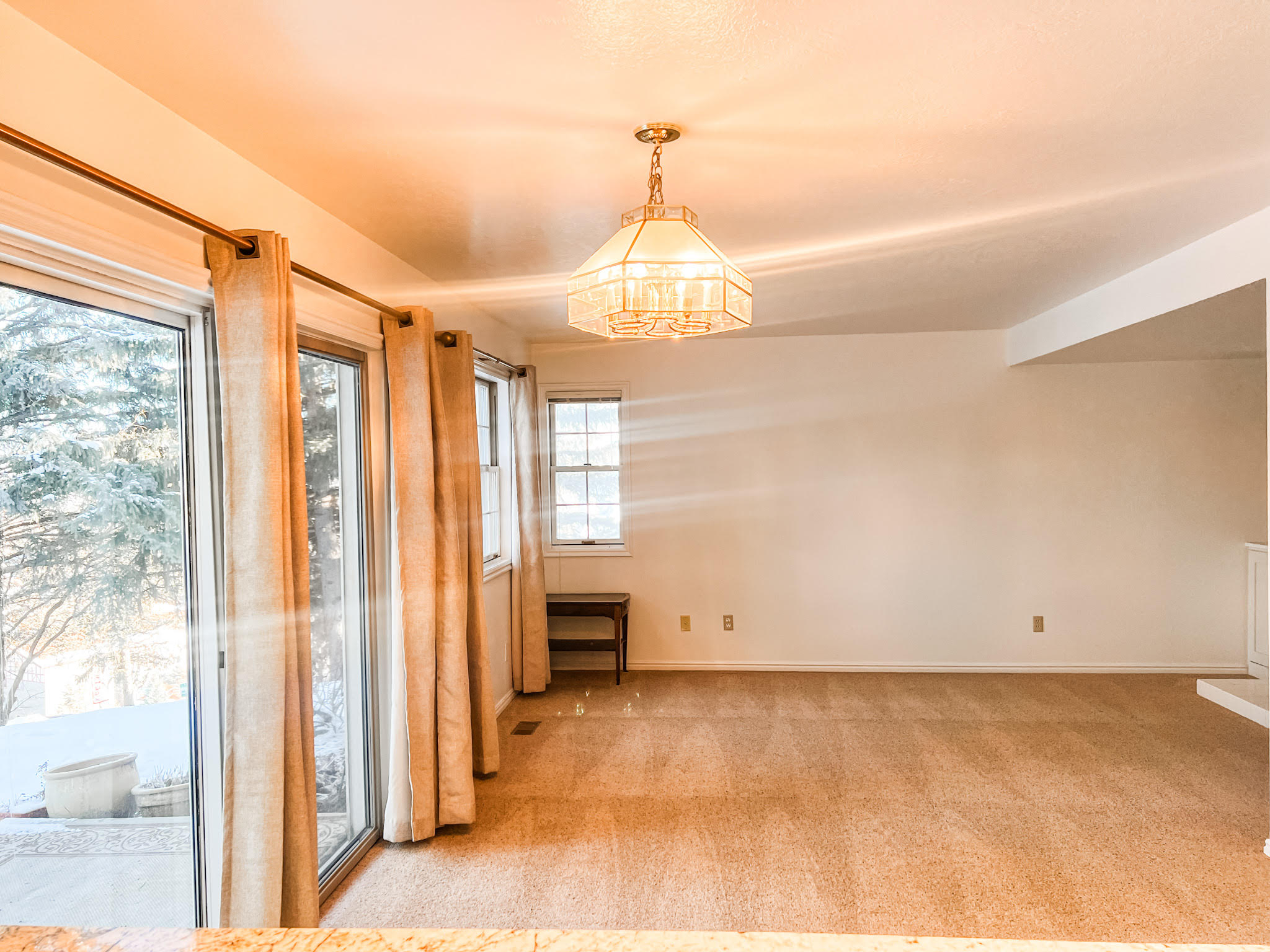 Unfurnished room featuring light carpet and a chandelier