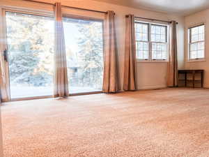 Spare room featuring carpet flooring and baseboards