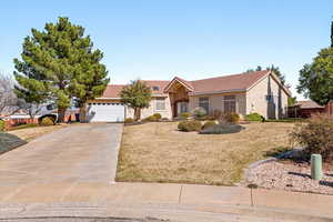 Ranch-style house featuring stucco siding, a front yard, a tile roof, concrete driveway, and an attached garage