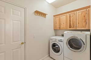 Laundry room featuring independent washer and dryer and cabinet space