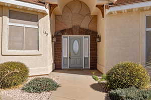 Doorway to property featuring stucco siding