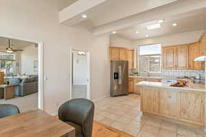 Kitchen featuring light countertops, light wood finish cabinetry, tasteful backsplash, stainless steel fridge, and recessed lighting