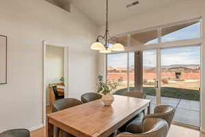 Dining space with light wood-type flooring, a mountain view, vaulted ceiling, and suspended lighting