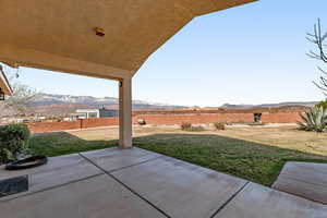 Fenced backyard with a mountain view and a patio area
