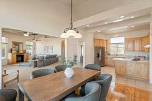 Dining room featuring recessed lighting, arched walkways, a fireplace, vaulted ceiling, and light wood finished floors