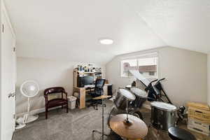Carpeted office space featuring a textured ceiling