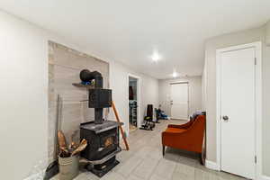 Living area featuring baseboards and a wood stove