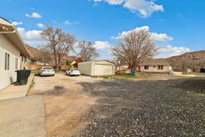 View of yard featuring a residential view, an outbuilding, a mountain view, and gravel driveway