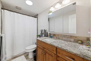 Full bath with vanity and light wood finished floors