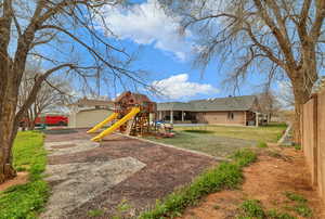 View of jungle gym with a trampoline and an outdoor structure